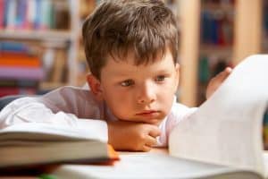 Jongen kijkt in boek - faalangst - voorkom faalangst en vergroot het zelfvertrouwen van je kind